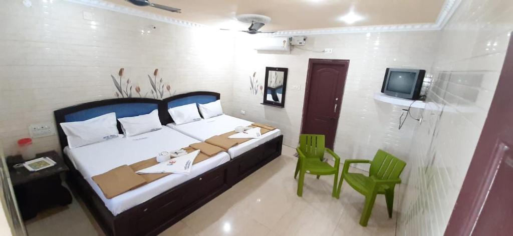 拉米斯瓦拉姆Hotel Prakash的一间卧室配有一张床、一张桌子和一台电视。