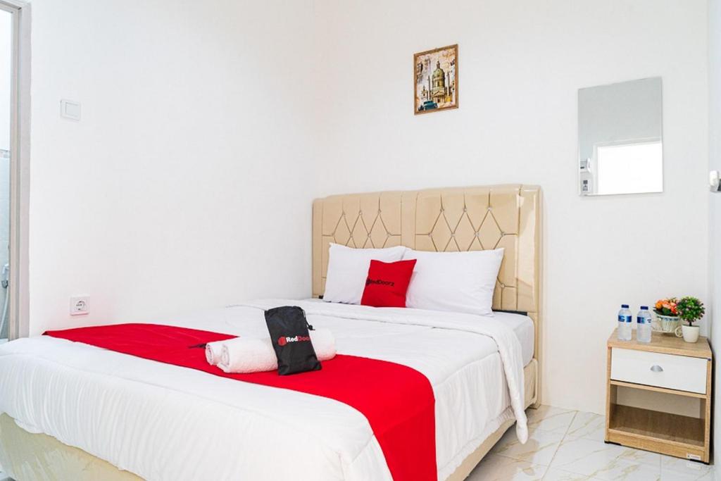 雅加达RedDoorz near Tarumanagara University的一间卧室配有一张带红色毯子的大床