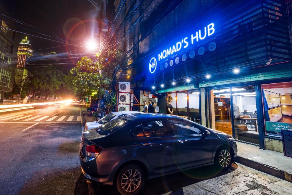 宿务Nomad's Hub - Best Value Co-living Hostel的夜间停在街道边的汽车