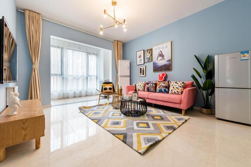 西安【路客】西安市未央区·大明宫公园·路客精品公寓·00174100的客厅配有粉红色的沙发和地毯。
