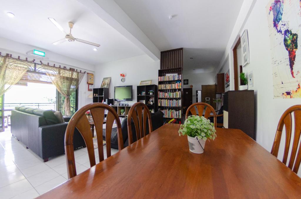 斯里巴加湾市Poni Homestay的一间带木桌和椅子的用餐室