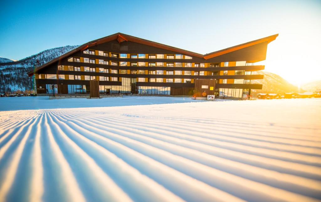 米尔克河谷Myrkdalen Resort Hotel的雪地中的一座建筑,有雪覆盖的地面