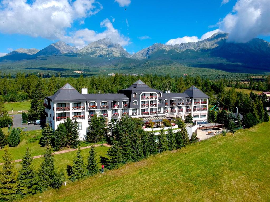 高塔特拉山Rodinný Hotel Hubert High Tatras的享有度假胜地的空中景致,以山脉为背景