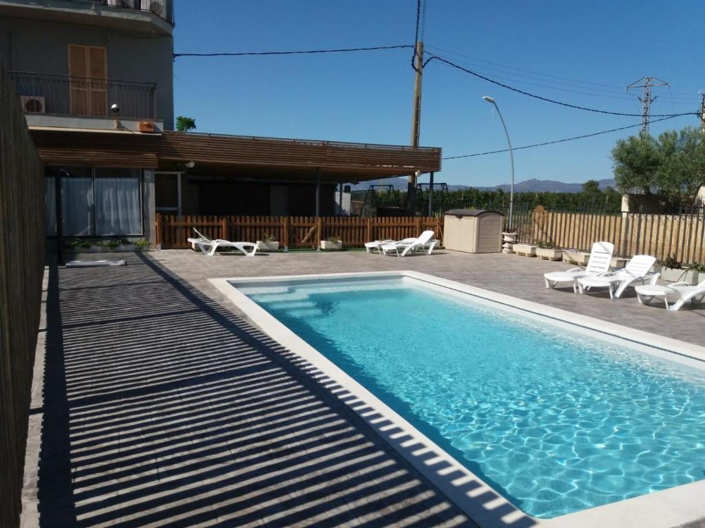 桑特佩尔佩斯卡多尔拉玛西亚酒店的一个带椅子的游泳池以及一座房子