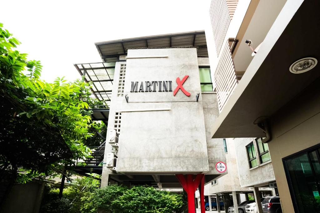 曼谷Matini Ratchada 32的建筑的侧面有一块马姆石标志
