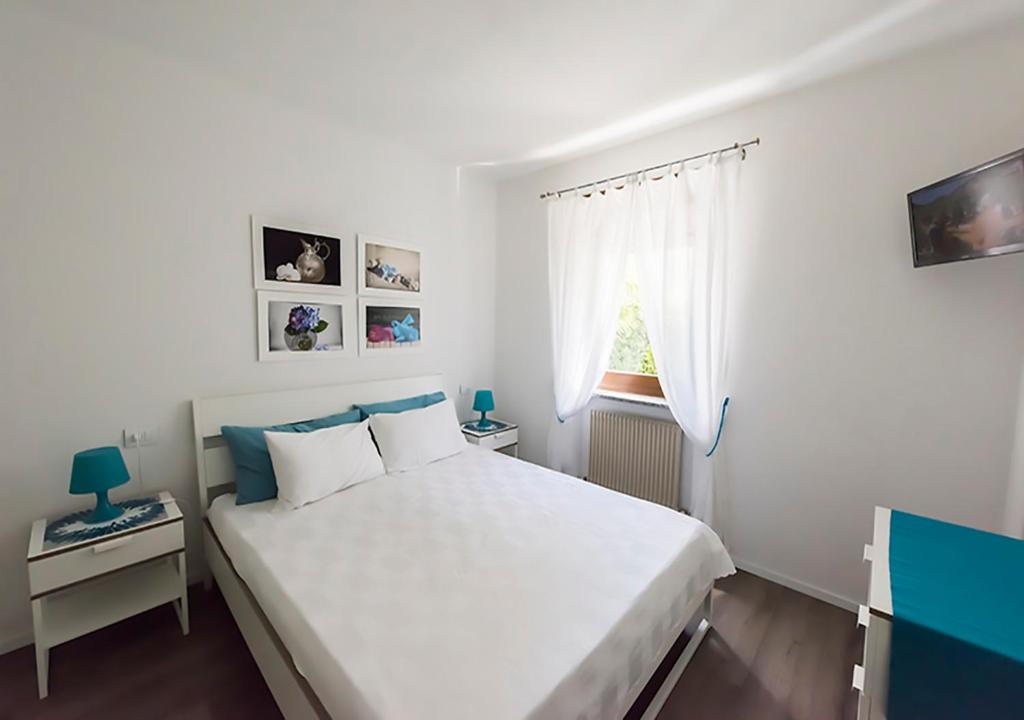 阿科Casa Vacanze RE.TI.的卧室设有一张白色大床和一扇窗户。