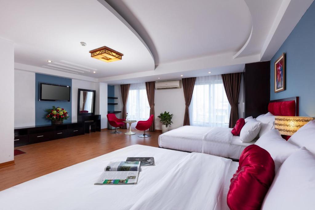 河内Hanoi Amore Hotel & Travel的酒店客房设有两张床和一台平面电视。