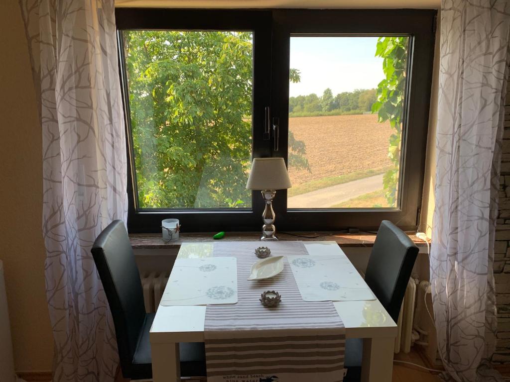 勒讷Ferienwohnung am Bramschebach的桌椅和享有田野景致的窗户