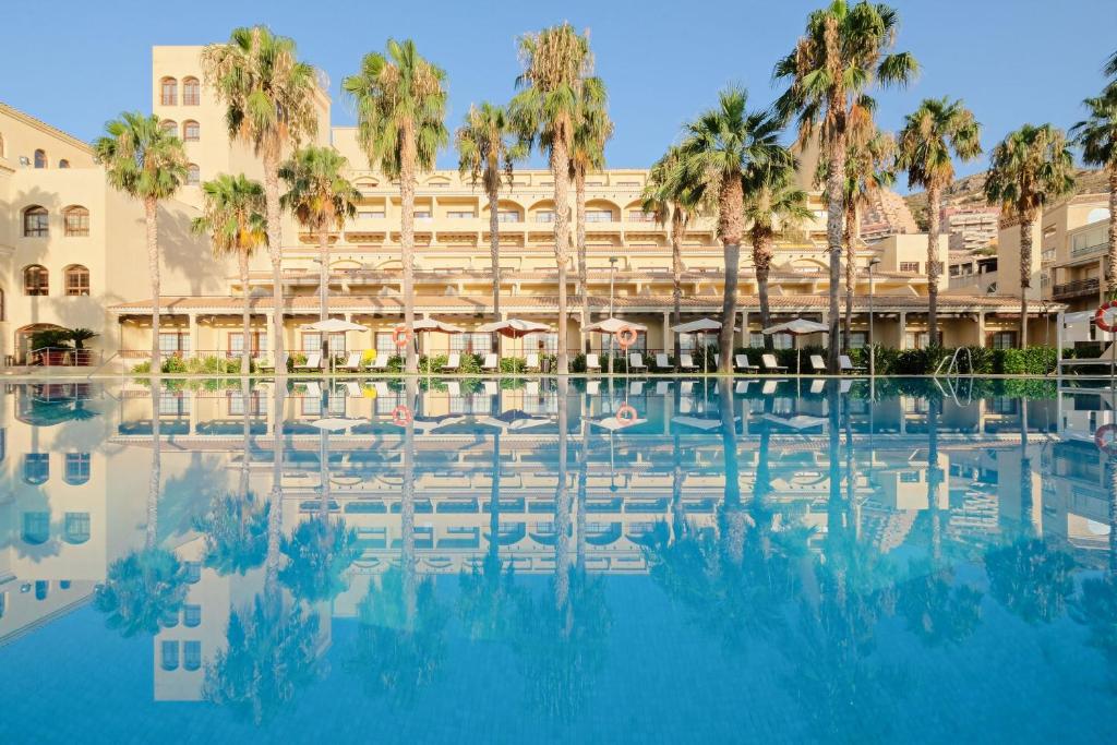 阿瓜杜尔塞Hotel Envia Almería Spa & Golf的享有棕榈树酒店和游泳池的景色