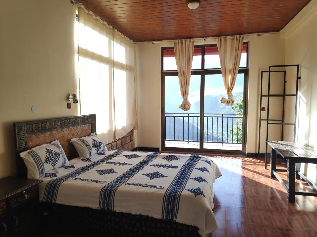 拉利贝拉Merkeza Guest House的一间卧室设有一张床和一个大窗户