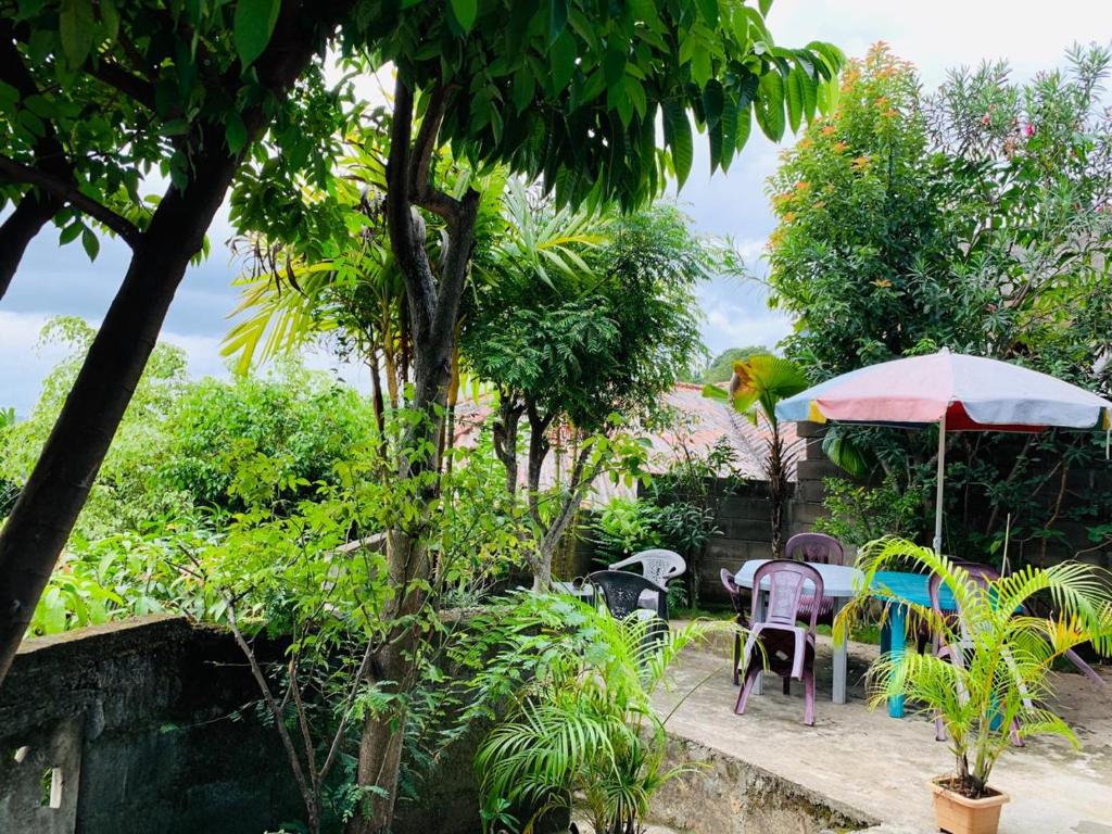 康提Jaga's Hill homestay的一个带桌椅和遮阳伞的庭院
