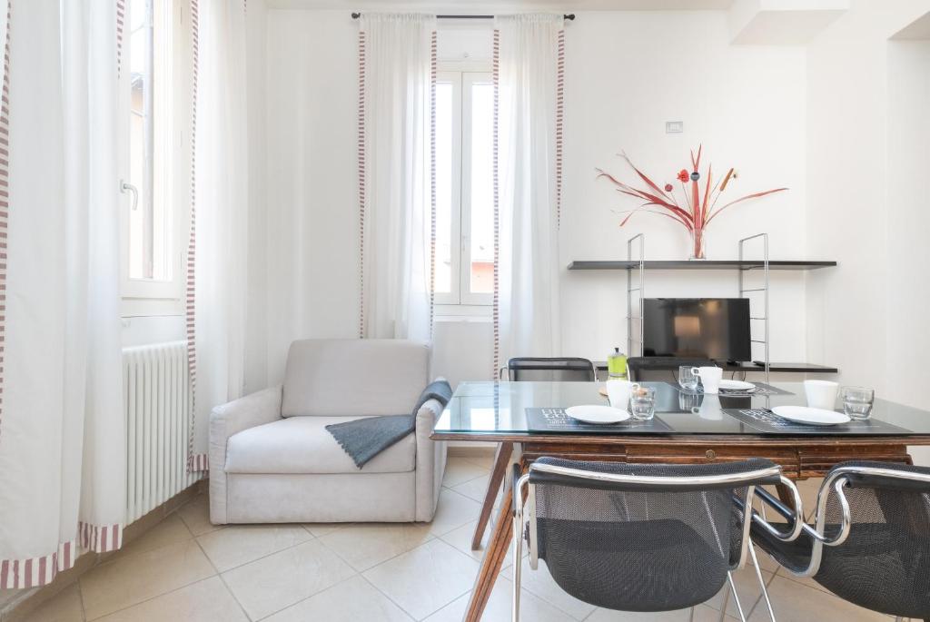 博洛尼亚Residenza Ariosto by Studio Vita的客厅配有桌子和椅子