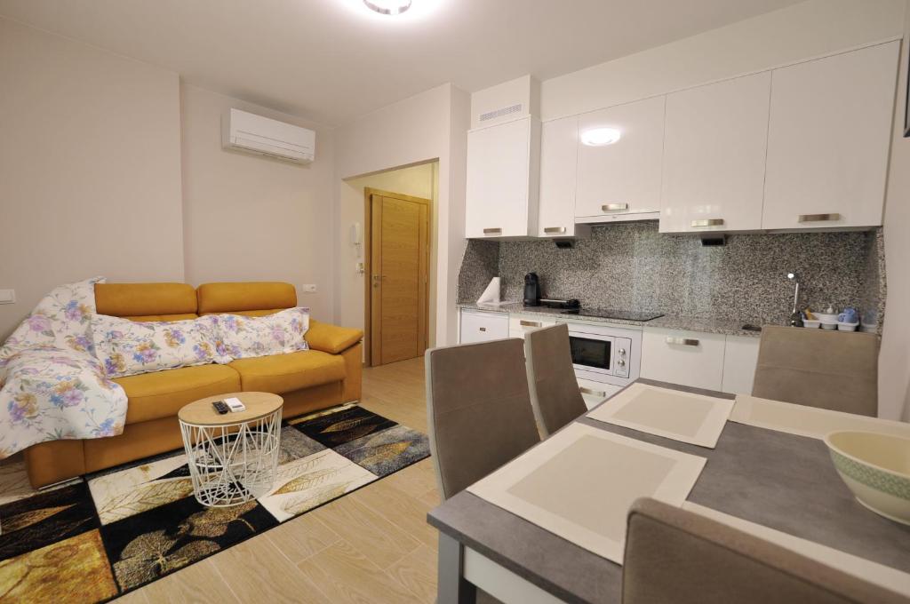维拉加尔西亚·德·阿劳萨Apartamentos Playa Compostela的厨房以及带沙发和桌子的客厅。