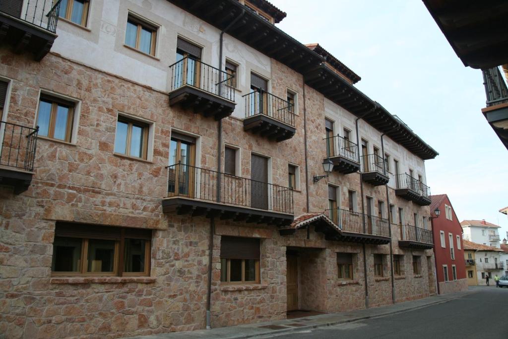 里亚萨HOTEL RURAL LA ROMEROSA的街道上一座古老的砖砌建筑,设有阳台