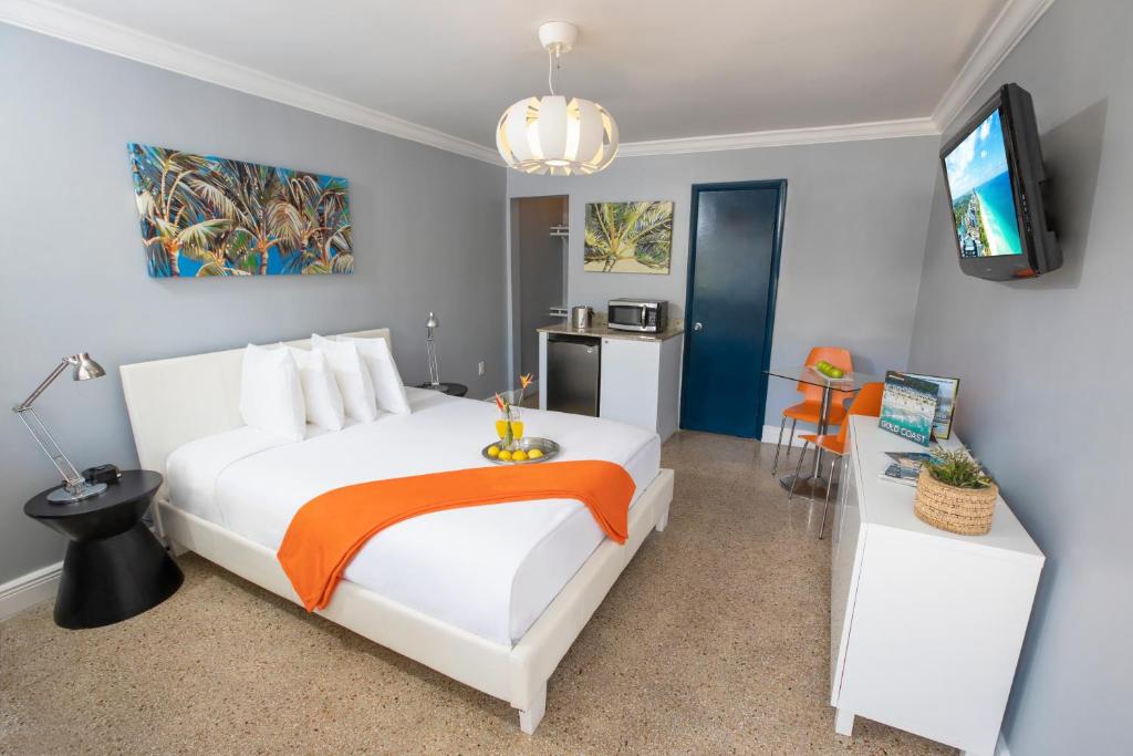 好莱坞好莱坞海滩套房及旅舍的一间卧室配有一张大白色床和橙色毯子