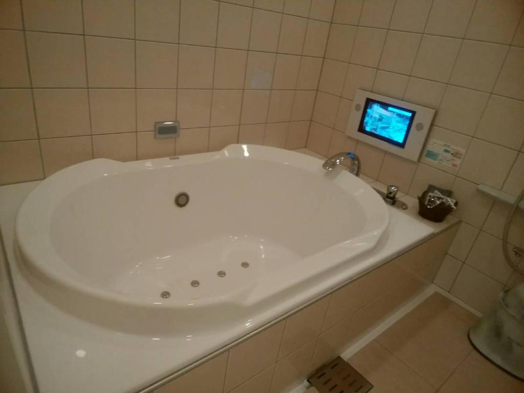 广岛Hotel PLAISIR (Adult Only)的带电视的浴室内的白色浴缸