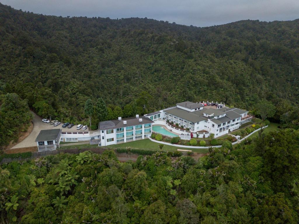 奥克兰Waitakere Resort & Spa的树林中一座大房子的空中景色