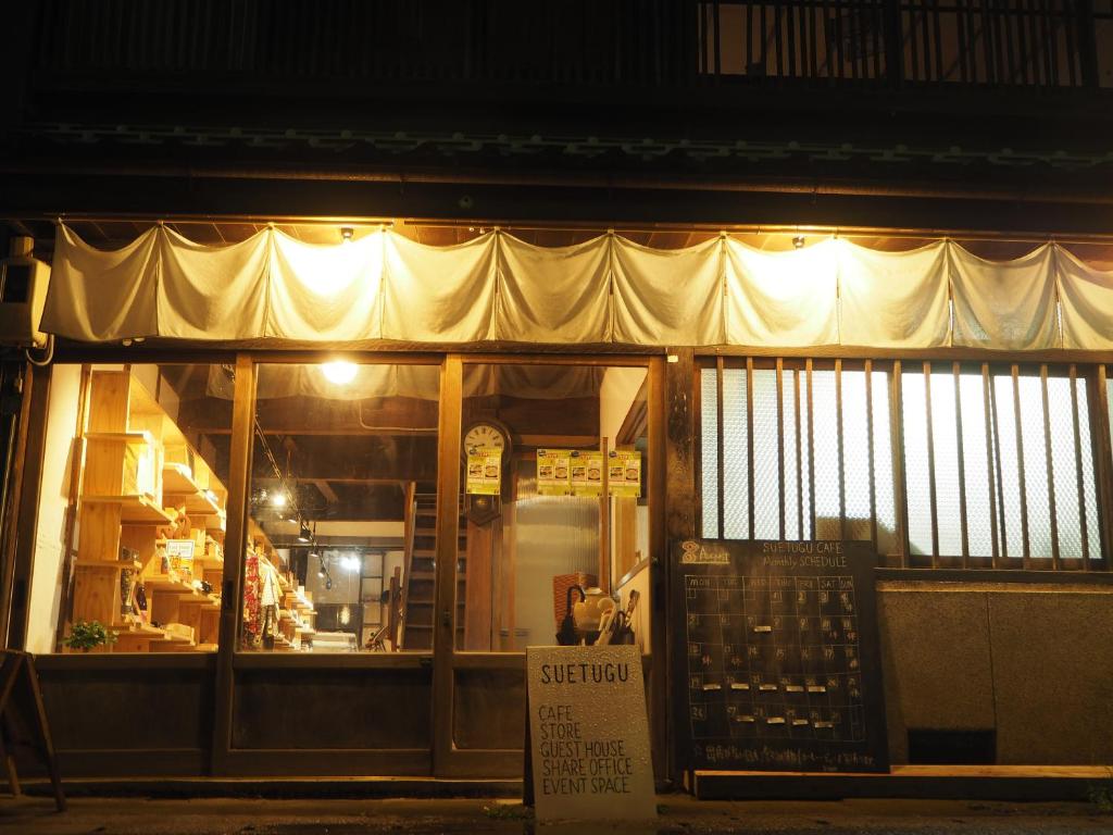 松江市Guest House SUETUGU的一间商店,晚上在店前有标牌