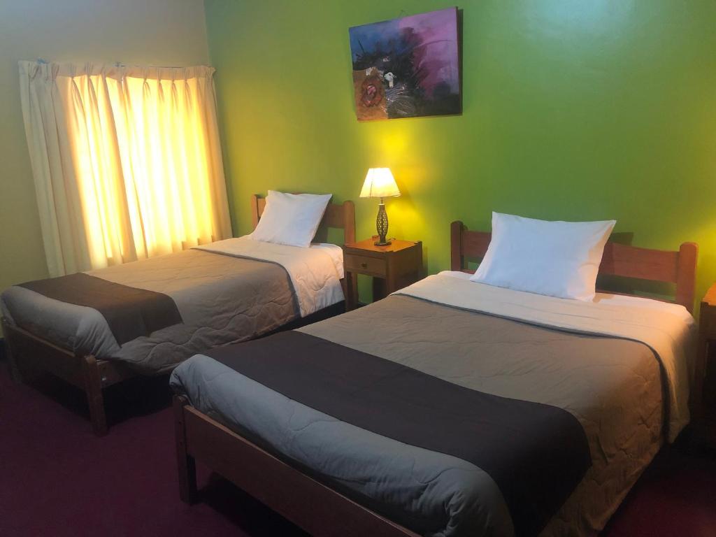 库斯科图利斯提克雷科莱塔旅舍的酒店客房设有两张床和窗户。