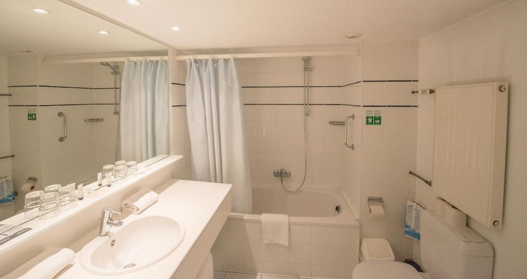 奥斯坦德奥斯坦德酒店的白色的浴室设有水槽和淋浴。