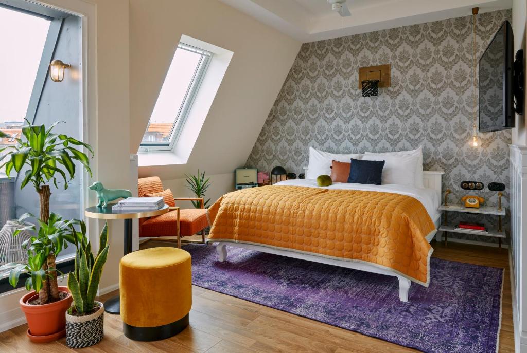柏林Max Brown Hotel Ku'damm, part of Sircle Collection的一间卧室配有橙色的床和紫色地毯