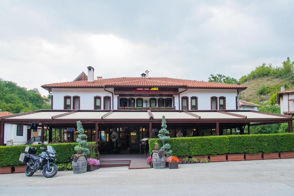 RozhenZlaten Rozhen Family Hotel- Monument of Cultural Significance的停在前面的一座带摩托车的建筑