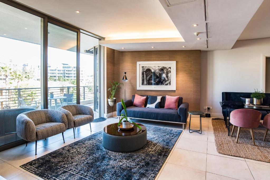 开普敦Elegant Waterfront Apartment with No Loadshedding的带沙发和钢琴的客厅