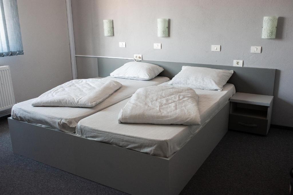 阿拉德Pensiunea Vlad的配有2张床的带白色床单和枕头的客房