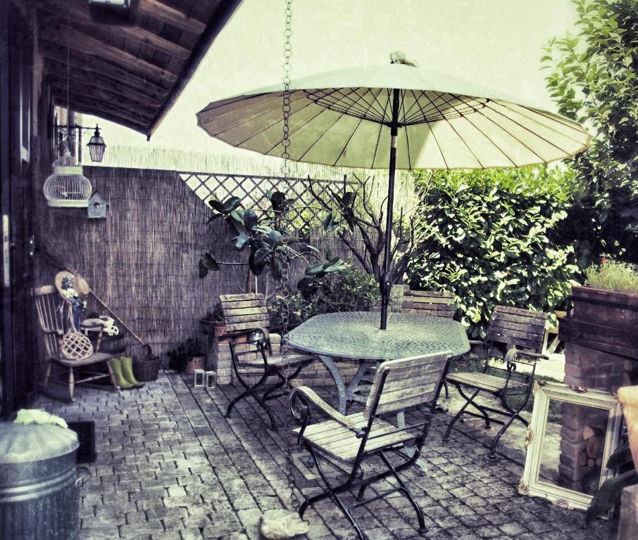 卡斯泰尔夫兰科埃米利亚马切罗堂乡村民宿的庭院配有桌椅和遮阳伞。