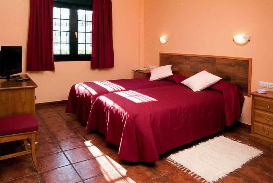 Cuesta de la Palma德尔波尼恩特田园酒店的一间卧室配有一张带红色毯子的大床