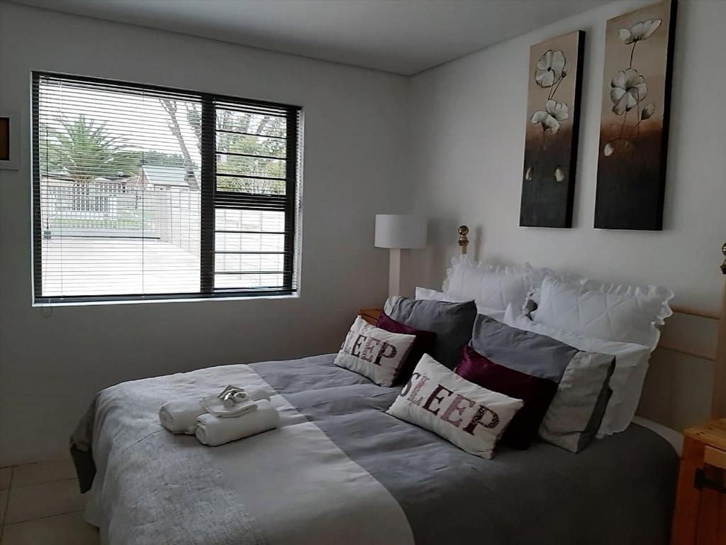 乔治Bergsight Self Catering Accommodation的卧室配有带枕头的大床和窗户。