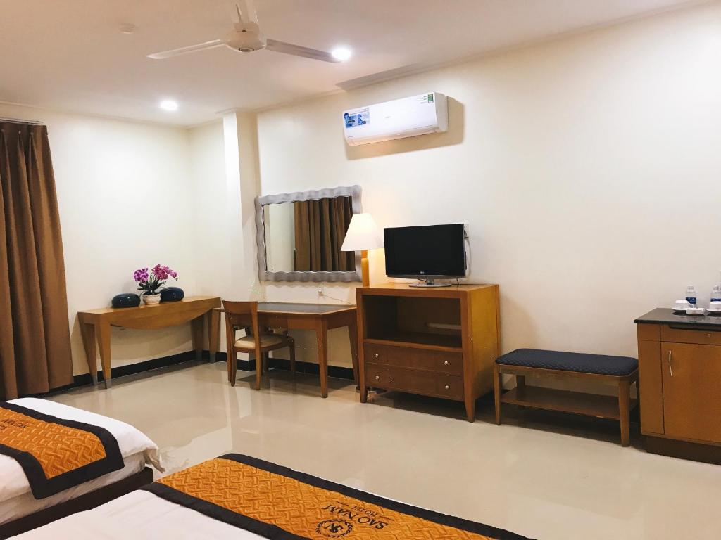 Cao LãnhKhách sạn SAO NAM的客房设有带书桌和电视的卧室。