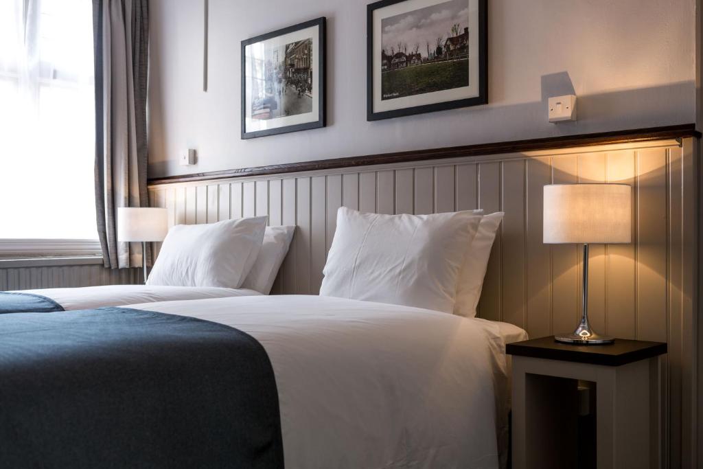 沃特福德南十字旅馆的酒店客房,设有两张床和一盏灯