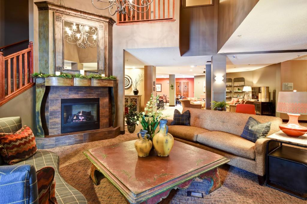 拉克罗斯GrandStay Hotel & Suites La Crosse的带沙发和壁炉的客厅