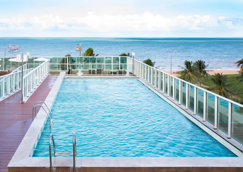 若昂佩索阿坦巴乌卢克索诺德酒店的一座背景海洋的游泳池