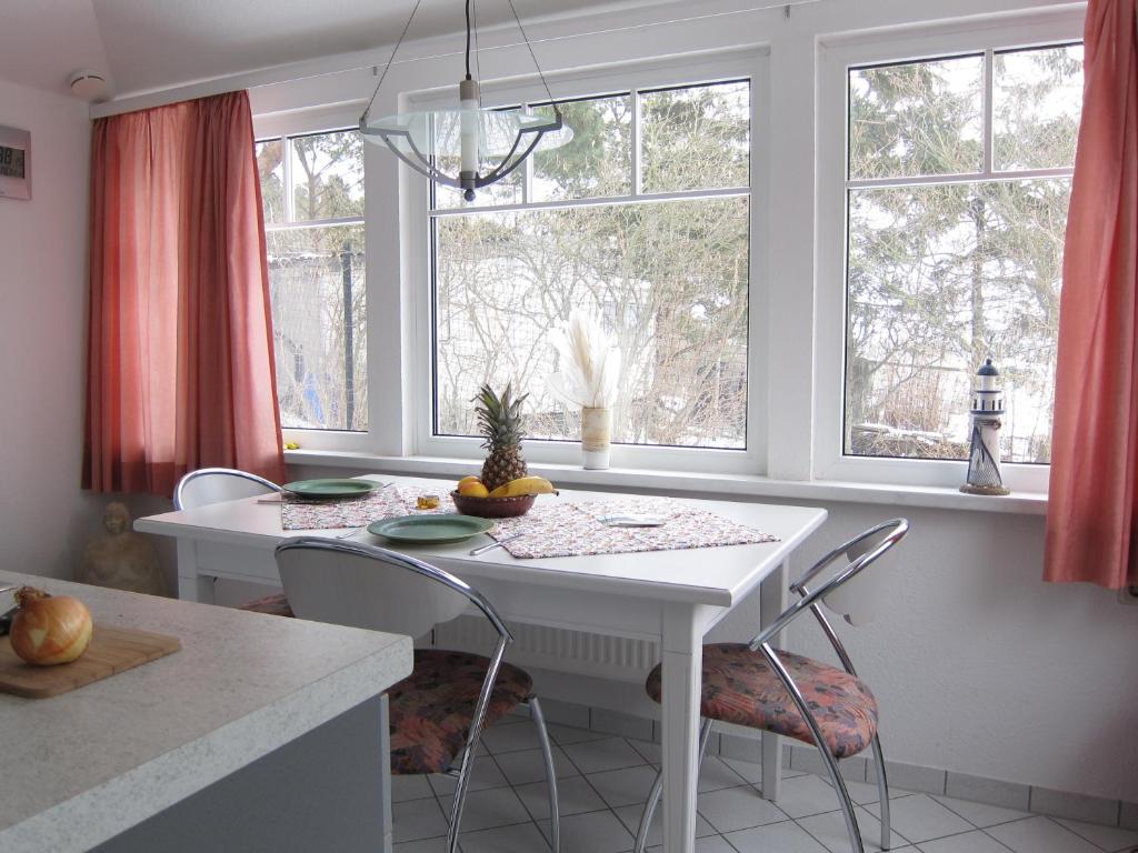 蒂索Uns Gartenhus mit Blick auf das Meer的厨房配有窗户,配有白色的桌椅