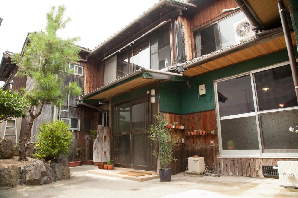 Shimo-yugeGuest House tokonoma的一座带大窗户和绿色外墙的建筑