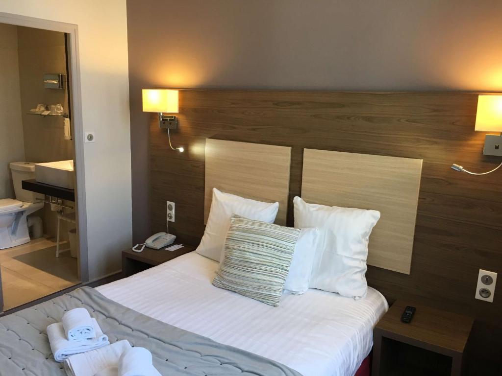 希农贝斯特韦斯特法兰西酒店的酒店客房配有带白色床单和枕头的床。
