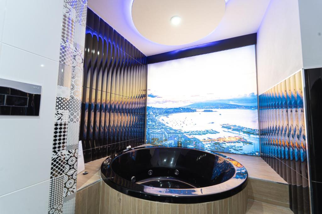 那不勒斯Al Campanile H Napoli Centro, by ClaPa Group的一间带黑色浴缸的浴室,配有大窗户