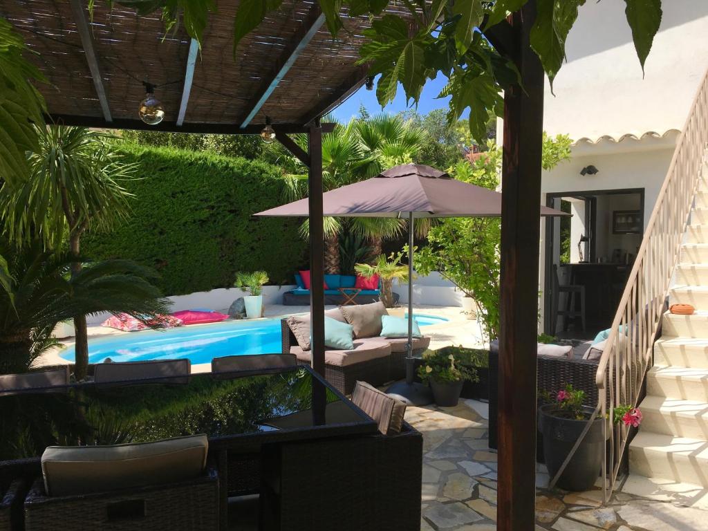 圣拉斐尔Bed,Kitchen and Swimming Pool Villa Esterel的一个带遮阳伞和游泳池的庭院