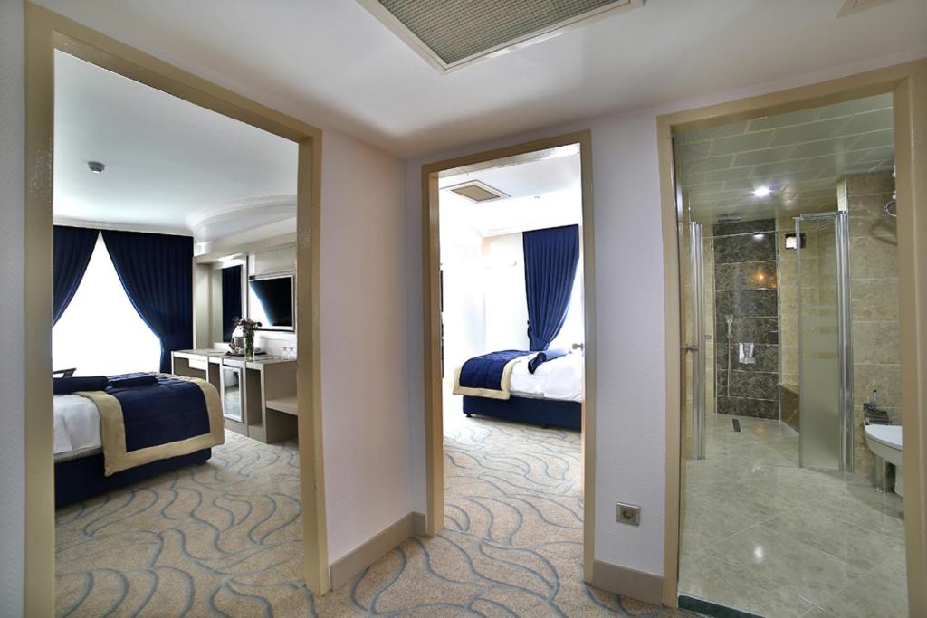 埃拉泽New Marathon Hotel的酒店客房设有两张床、淋浴和一间浴室。
