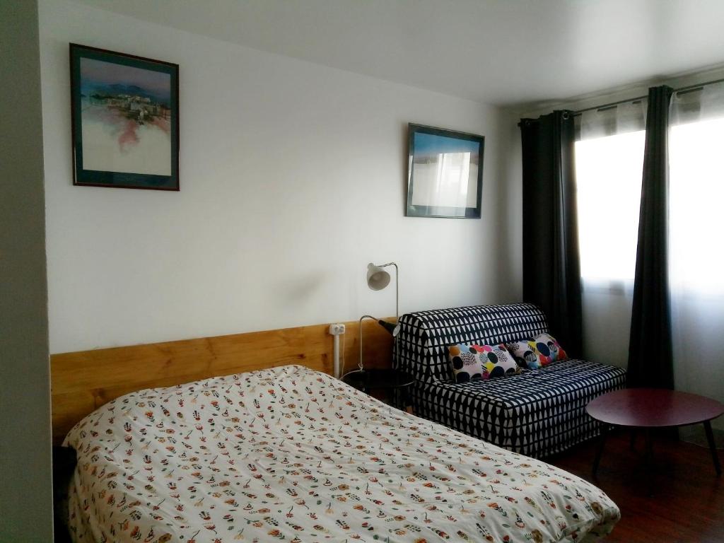 沙朗通勒蓬Charenton Home的卧室配有床、椅子和窗户。