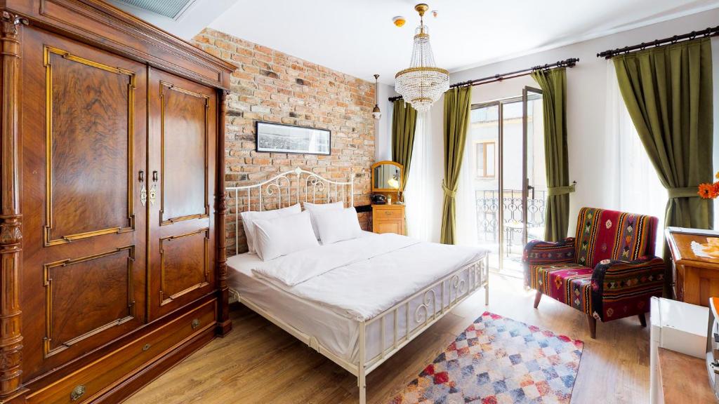 伊斯坦布尔Hotel Des Arts Galata的一间卧室设有一张床和砖墙