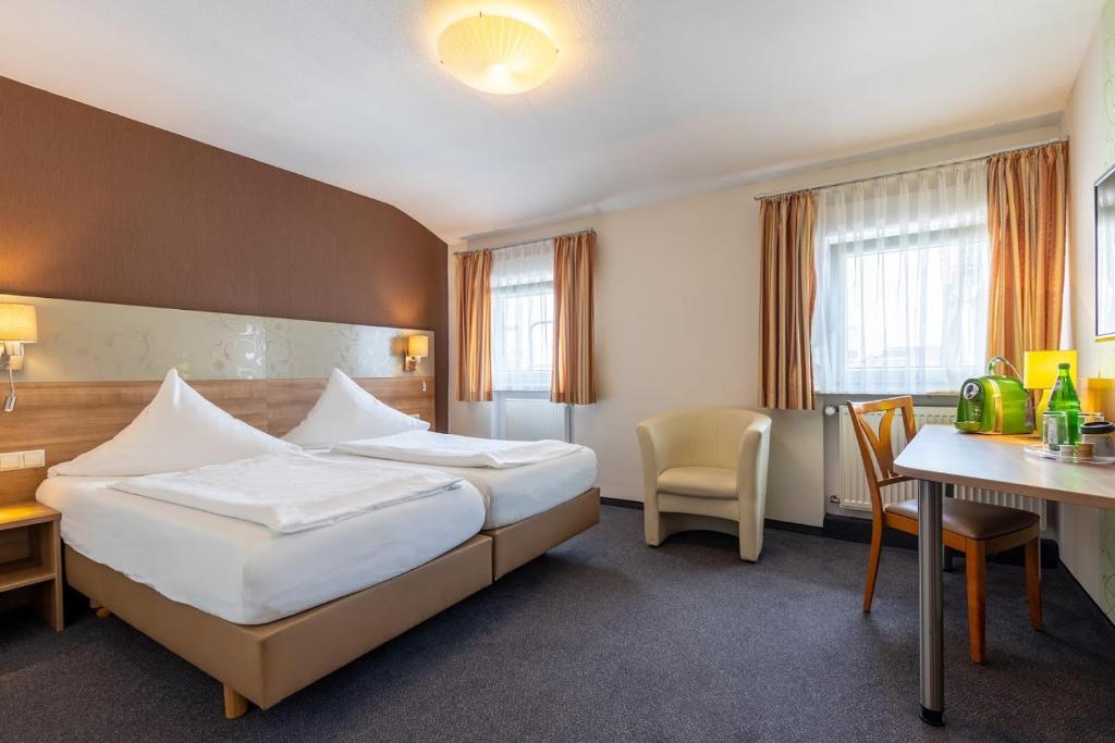 科布伦茨Trip Inn Hotel Hamm的酒店客房配有一张床铺和一张桌子。