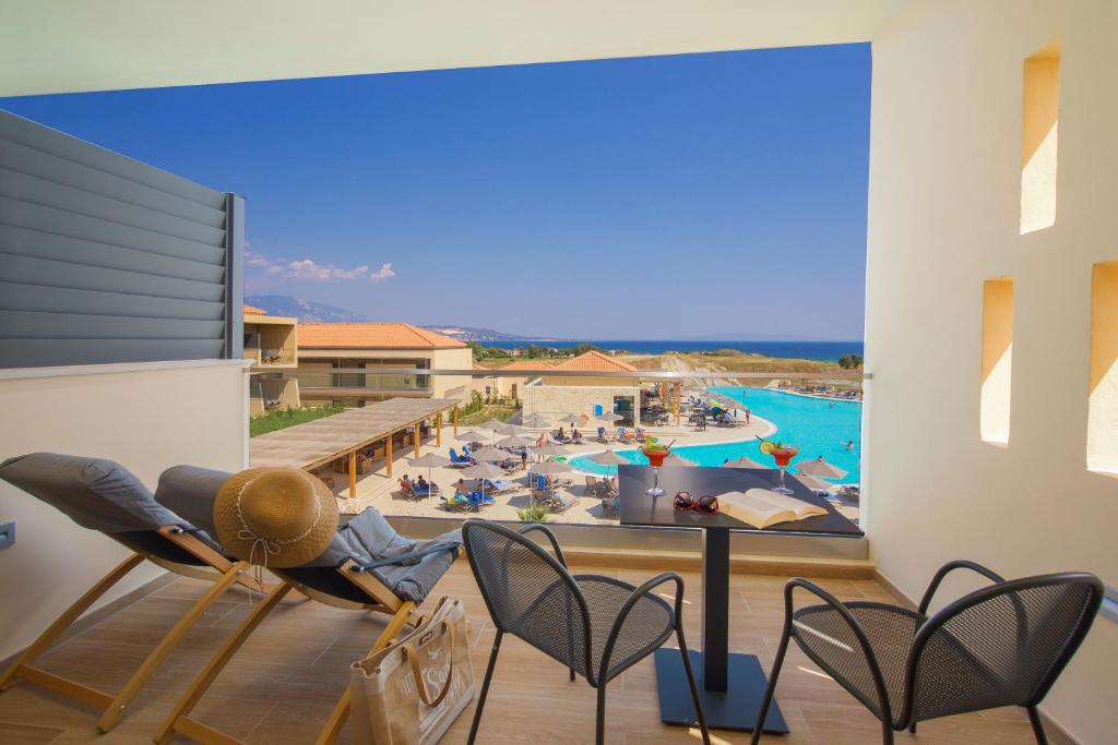希伊Apollonion Asterias Resort and Spa的从度假村的阳台可欣赏到游泳池的景色