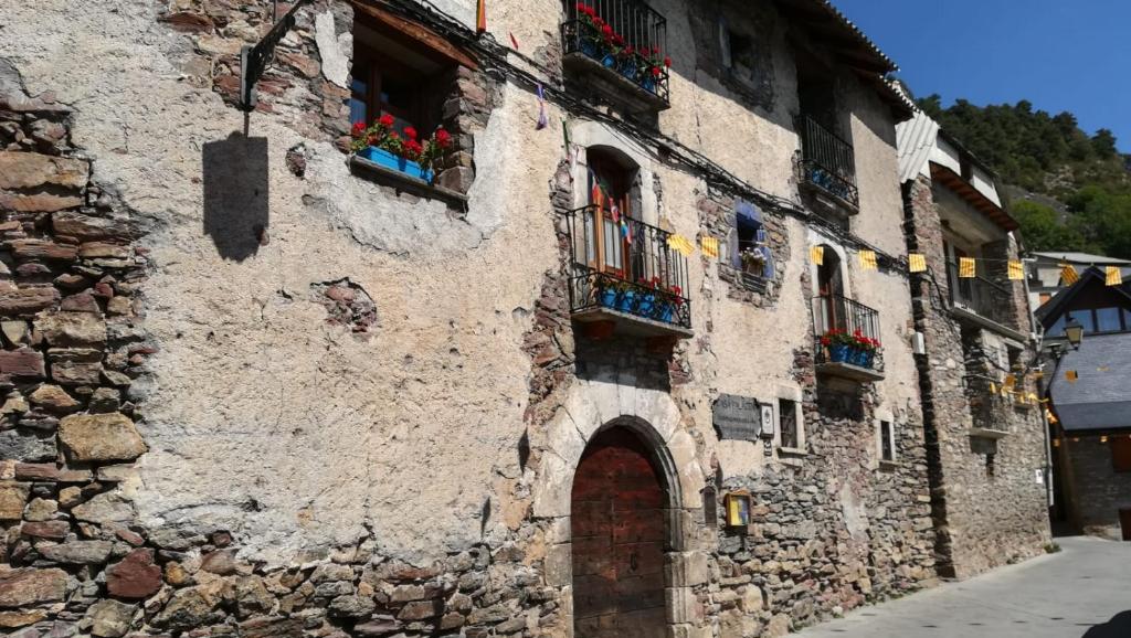 GistaínCasa Palacin的一座带窗户和门的古老石头建筑
