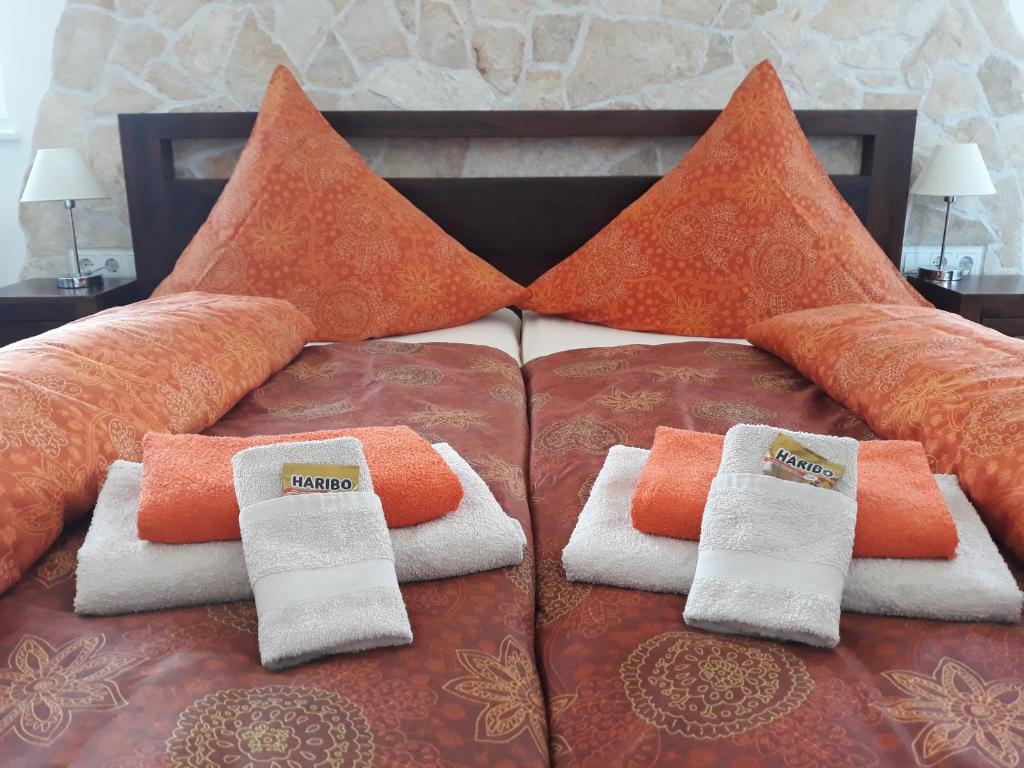 艾森纳赫Gästehaus Wohngut Eisenach的床上有橙色和白色的毛巾