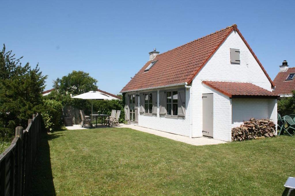 布列登Vakantienestje的白色的房子,有栅栏和院子