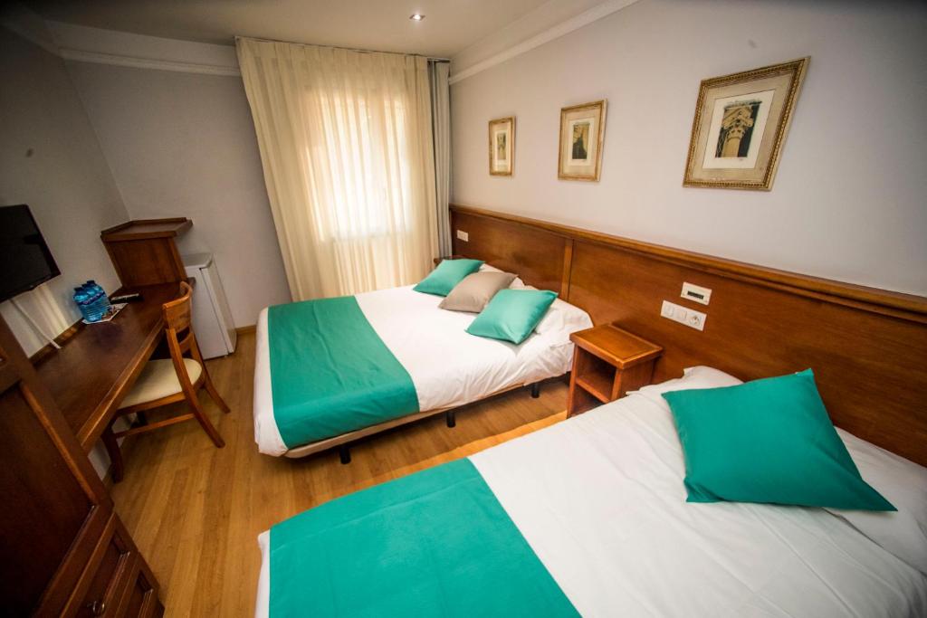 索里亚Hotel Alba的酒店客房配有两张床和一张书桌