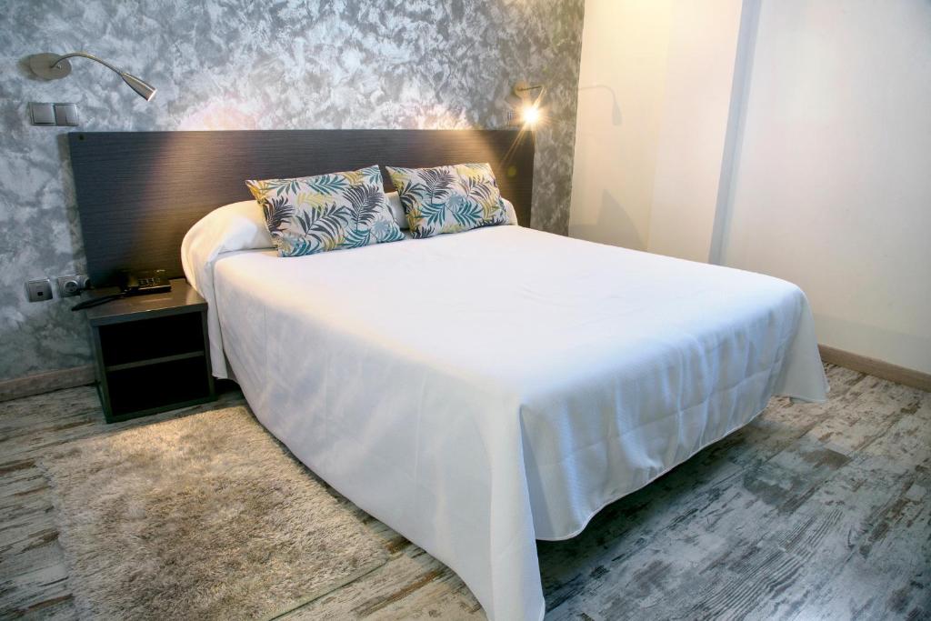 圣拉菲尔芬卡拉卡索纳高级客房酒店的卧室配有一张白色大床和床头板